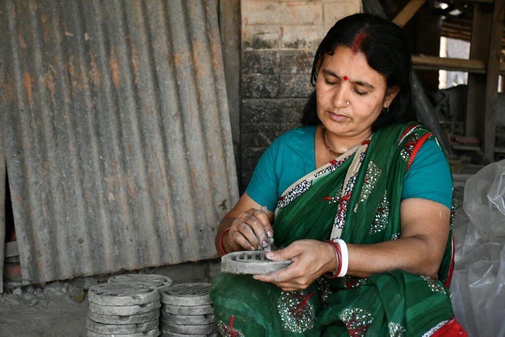 South Asian woman crafting traditional clay art in sari. Captive detail of cultural heritage.
